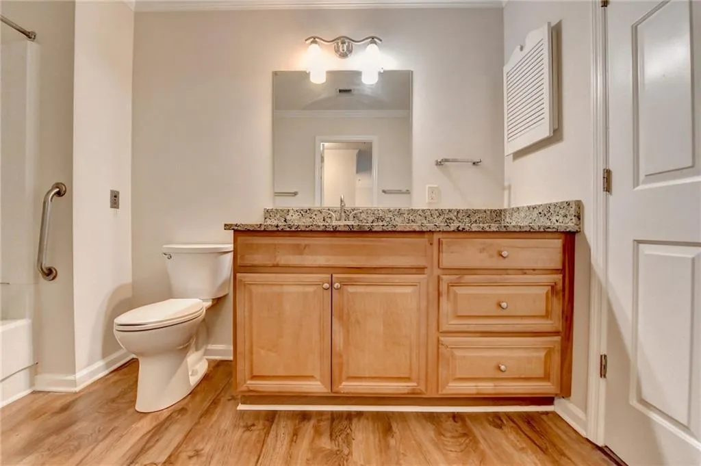 Full bathroom featuring shower / washtub combination, vanity, toilet, and hardwood / wood-style floors