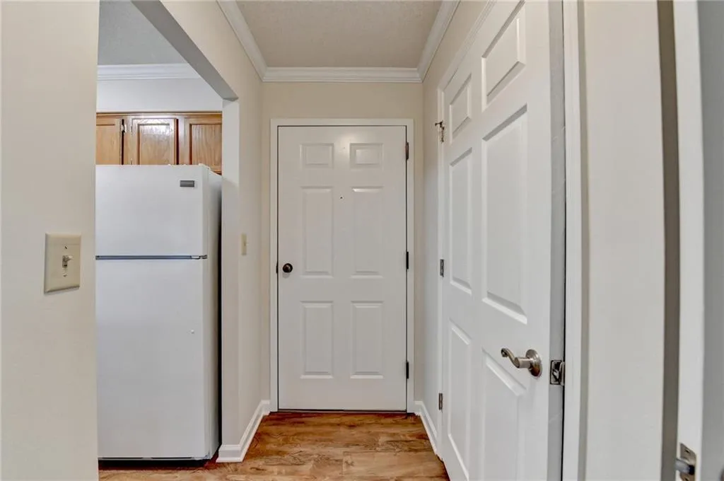 Doorway featuring light hardwood / wood-style flooring and crown molding