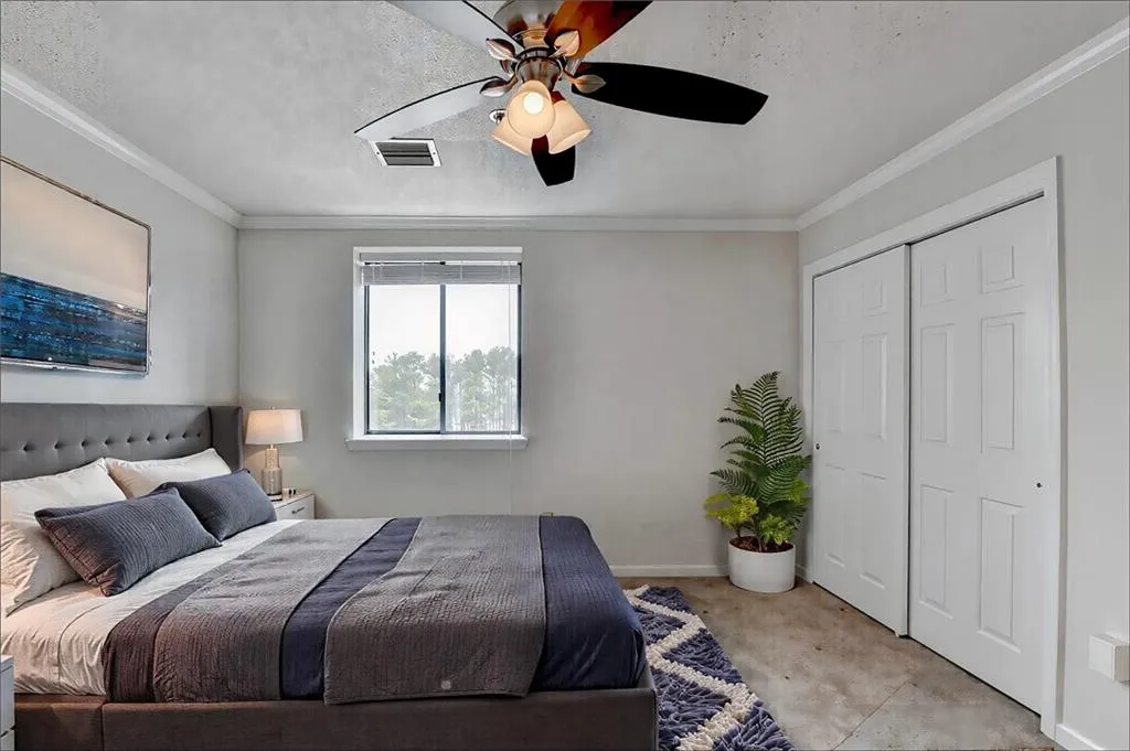 Bedroom featuring crown molding, ceiling fan, and a textured ceiling