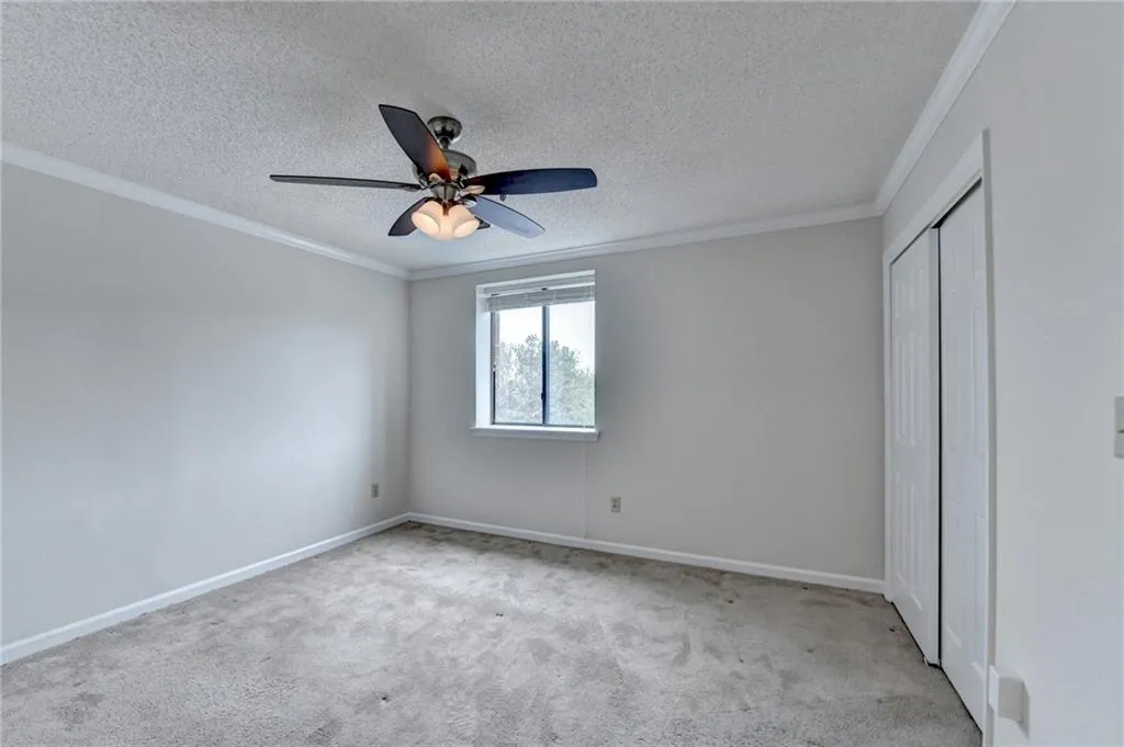 Unfurnished bedroom featuring crown molding, light carpet, and a closet
