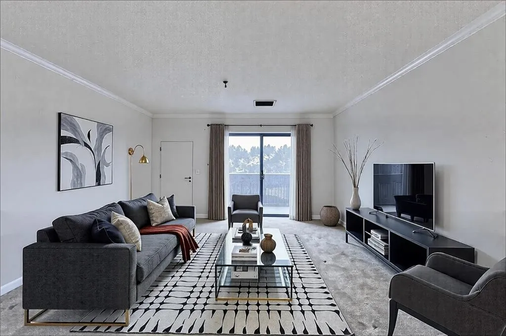 Living room featuring crown molding, carpet floors, and a textured ceiling