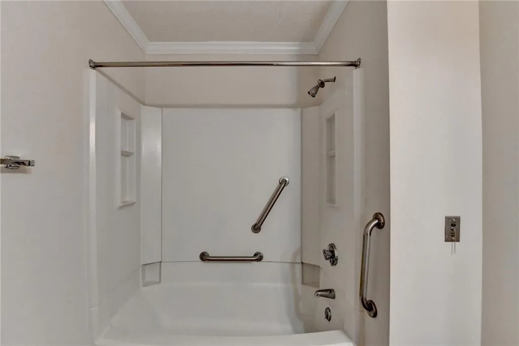 Bathroom with crown molding and tub / shower combination