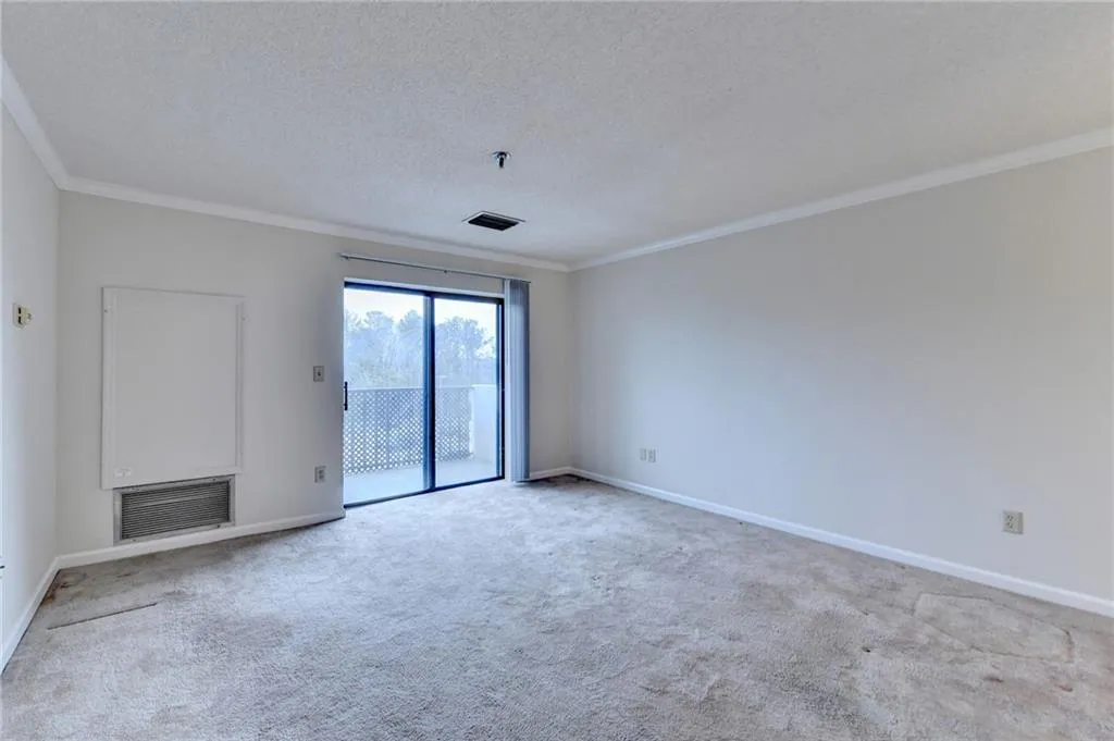 Spare room featuring carpet, ornamental molding, and a textured ceiling