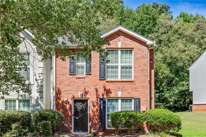 Brick exterior with black shutters and a black entry door