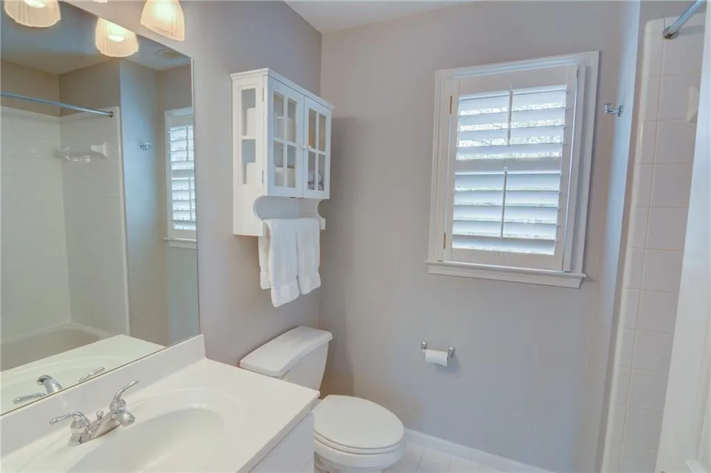 Bathroom featuring vanity, shower / bath combination, and light tile patterned floors