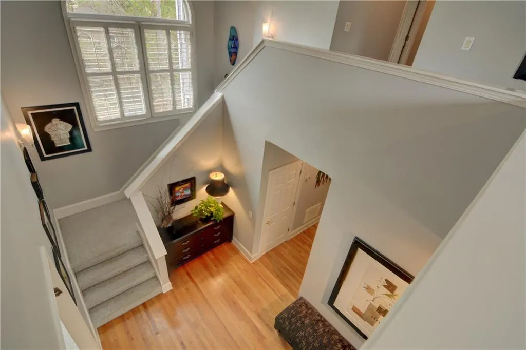 Stairs featuring wood finished floors and a high ceiling