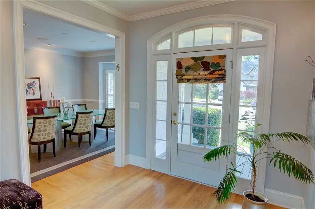 Foyer entrance with crown molding and light wood-type flooring