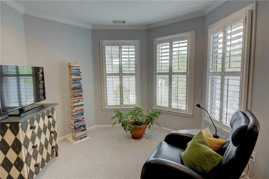 Sitting room featuring light carpet and ornamental molding