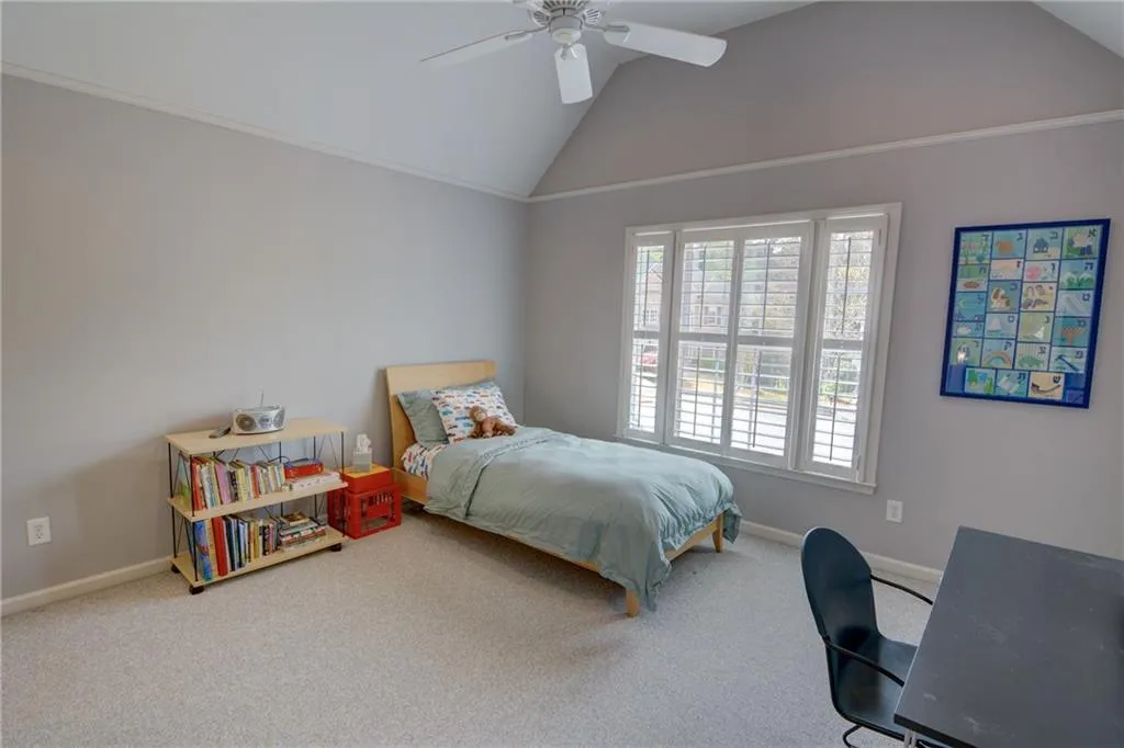 Carpeted bedroom featuring baseboards and a ceiling fan