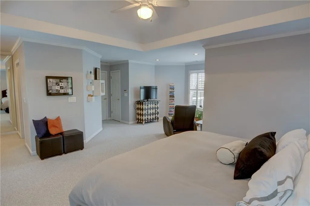 Bedroom featuring carpet floors, a raised ceiling, crown molding, ceiling fan, and recessed lighting