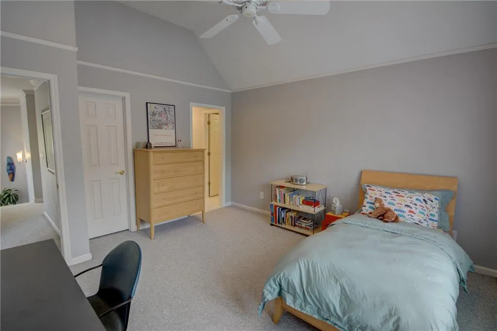 Bedroom featuring light colored carpet, vaulted ceiling, ceiling fan, and ornamental molding