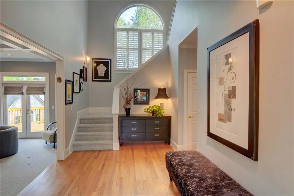 Foyer entrance with light wood-type flooring, french doors, and crown molding