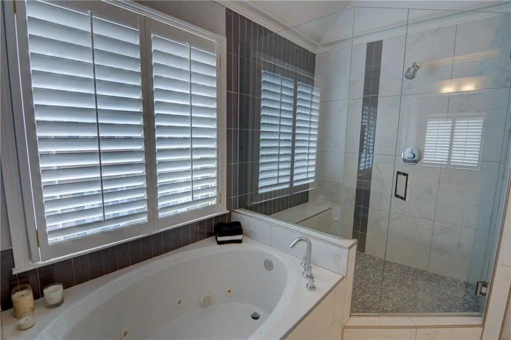 Full bath featuring a jetted tub and a stall shower