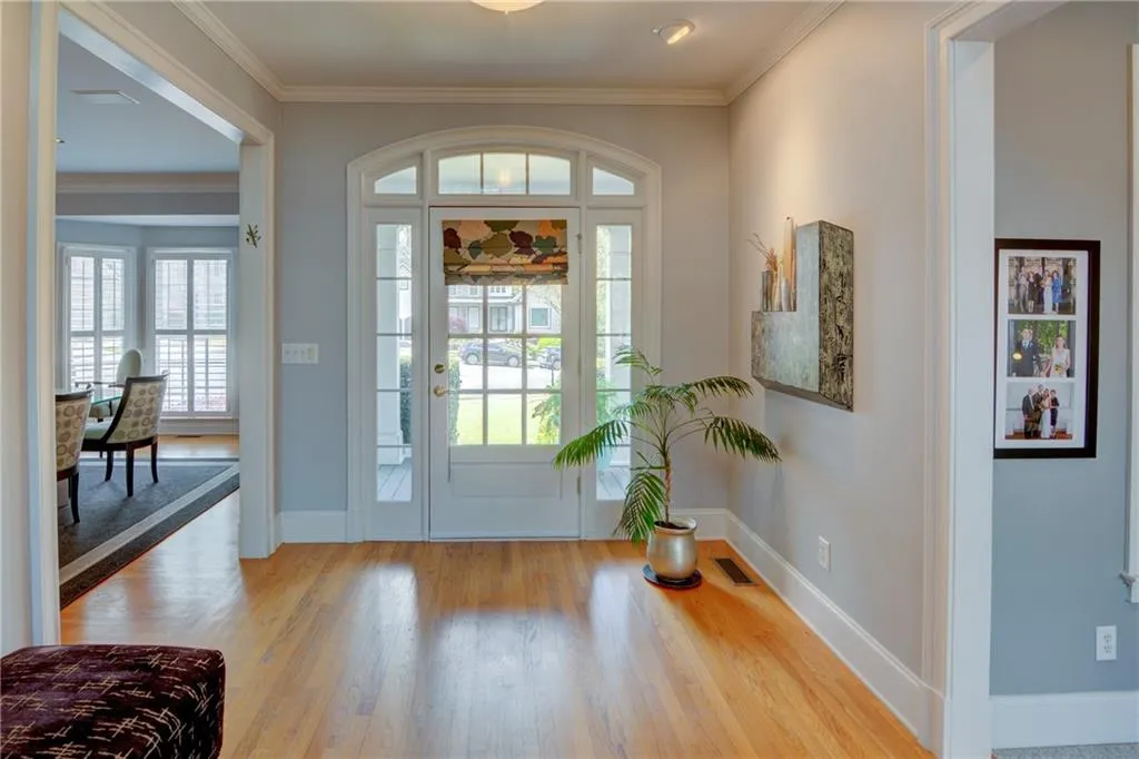 Foyer entrance featuring ornamental molding, plenty of natural light, and wood finished floors