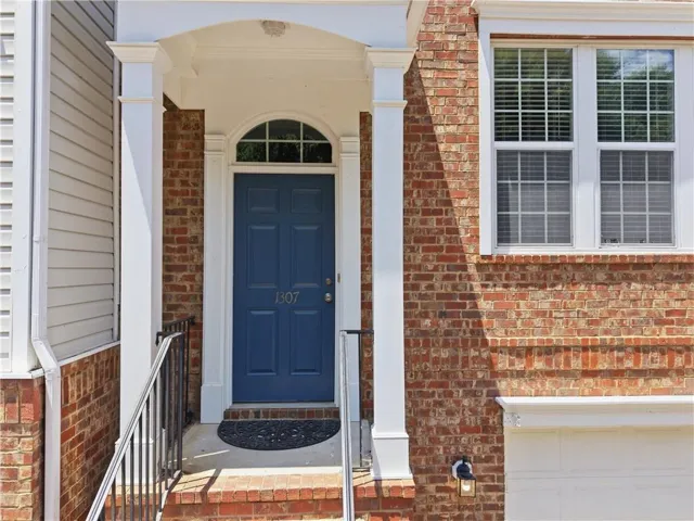 Brick facade with white trim, arched transom window above the entrance, and a blue panel door