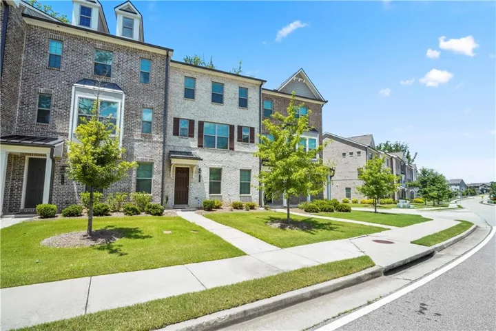 Brick townhome exterior featuring multiple window styles, including a bay window