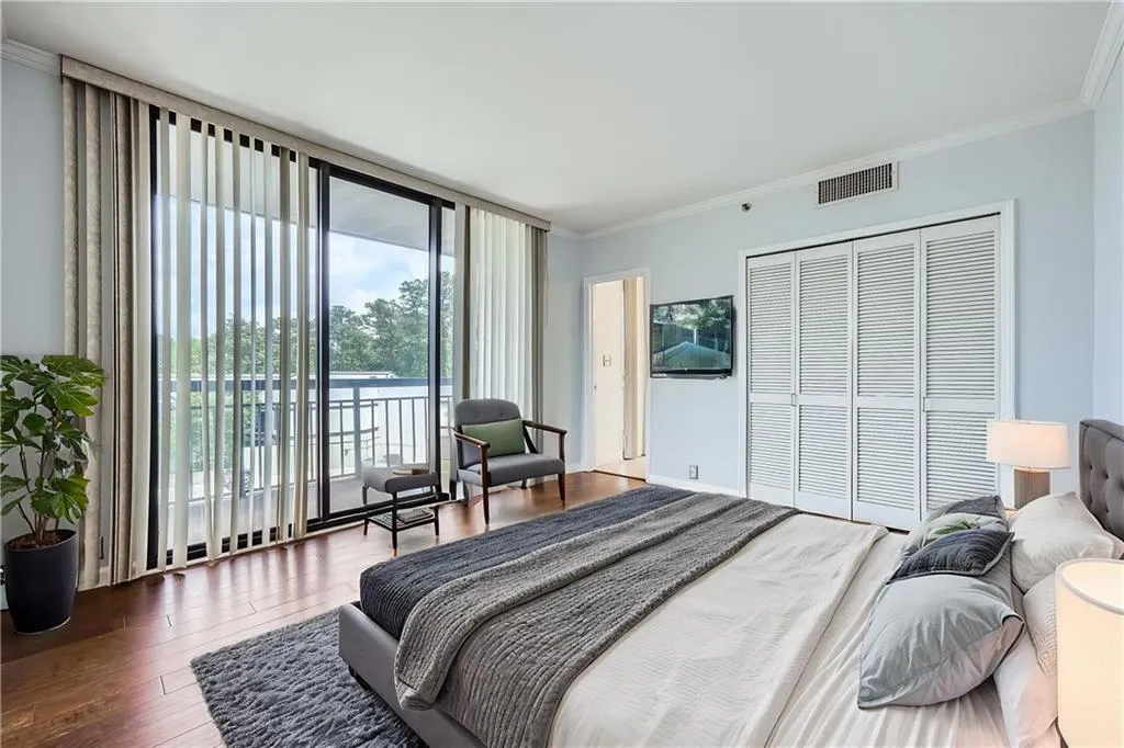 Bedroom featuring access to exterior, floor to ceiling windows, crown molding, wood finished floors, and a closet