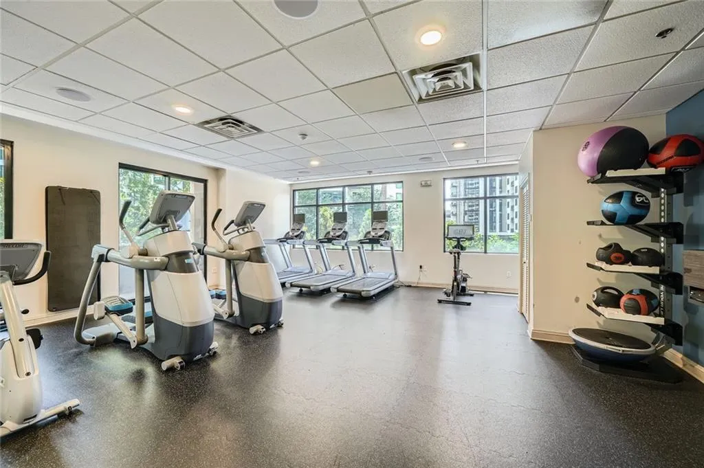 Workout area with a drop ceiling, baseboards, and recessed lighting