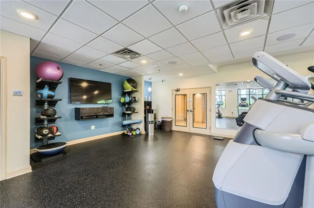 Workout area featuring a drop ceiling, baseboards, and french doors