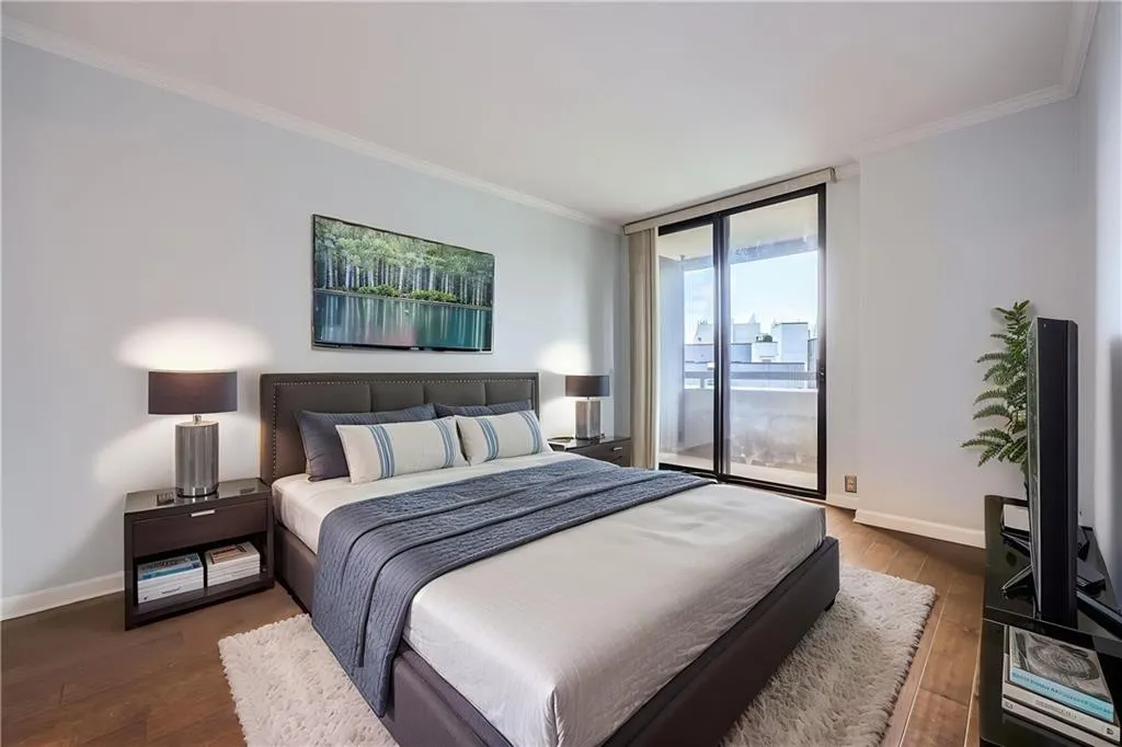 Bedroom featuring access to exterior, ornamental molding, baseboards, and wood finished floors