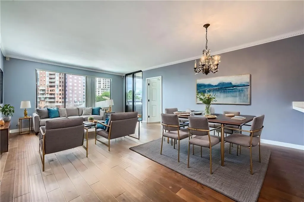 Dining area featuring ornamental molding, a chandelier, baseboards, and wood finished floors