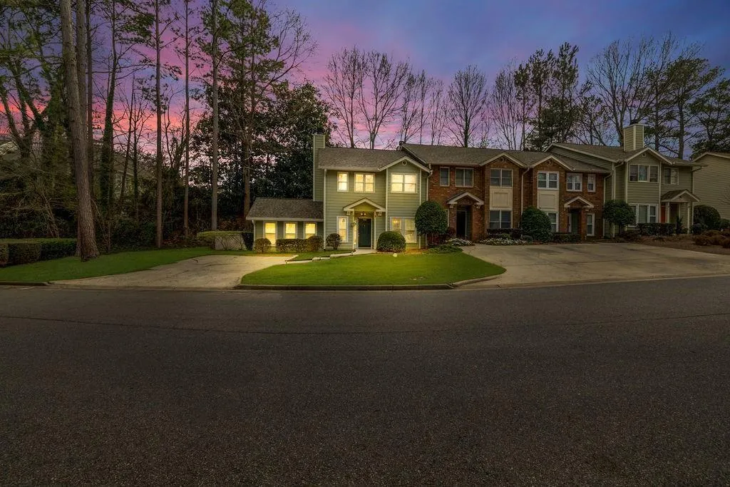 View of front of house featuring driveway, a chimney, and a front yard