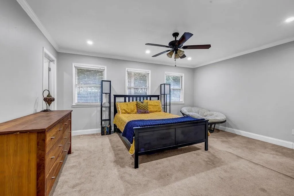 Bedroom with recessed lighting, light colored carpet, crown molding, and baseboards