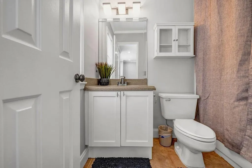 Bathroom with vanity, crown molding, and toilet