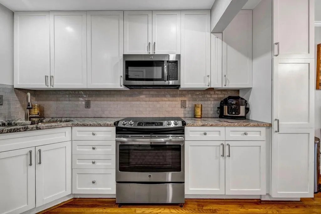 Kitchen with a sink, white cabinets, and stainless steel appliances