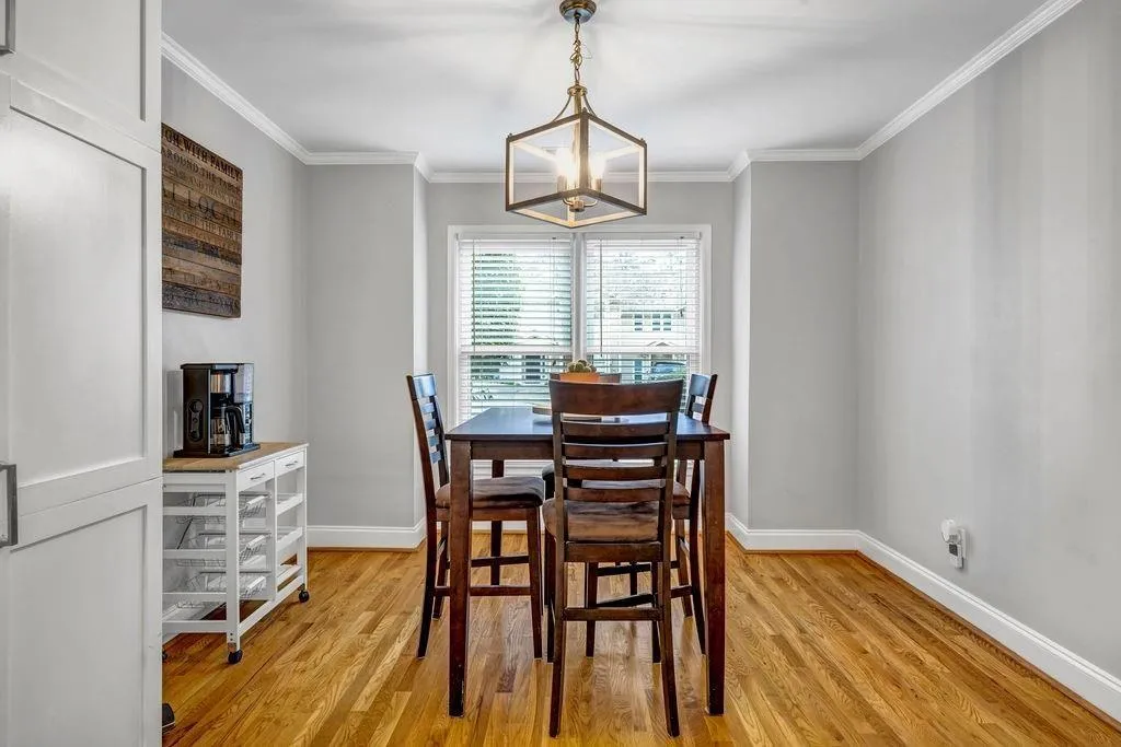 Dining area with baseboards, ornamental molding, and light wood finished floors