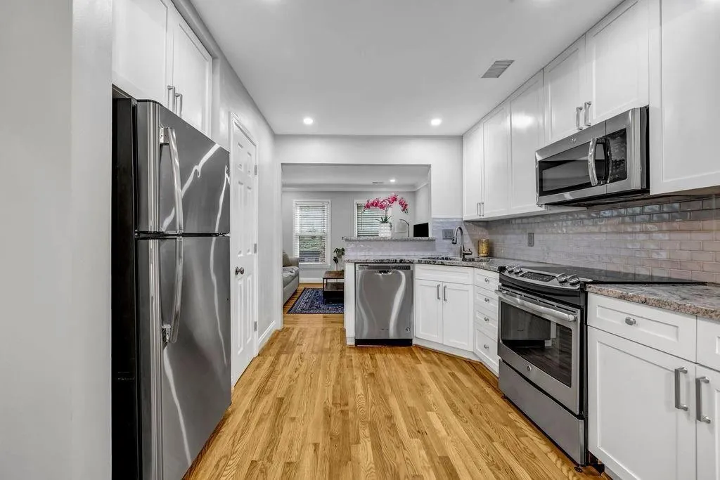 Kitchen with visible vents, backsplash, appliances with stainless steel finishes, and white cabinets