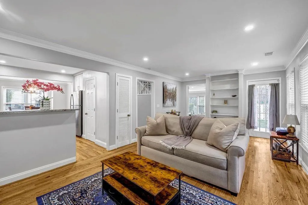 Living room with baseboards, plenty of natural light, and light wood-style floors