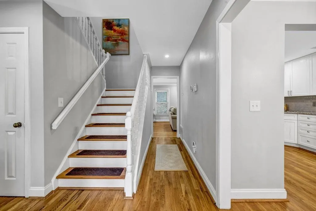 Stairs with wood finished floors and baseboards