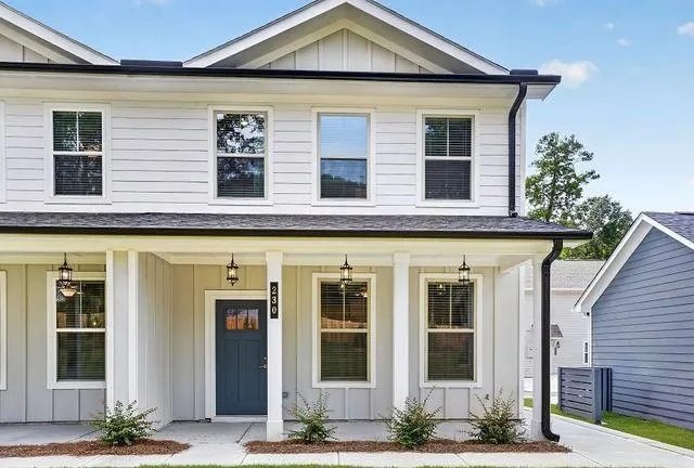 Modern two-story facade featuring light siding, a dark roof, and a covered porch