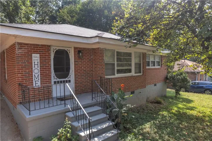 Single story home with crawl space, brick siding, covered porch, and a front yard