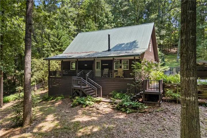 Wood-sided exterior featuring an A-frame roofline and a front porch with railing