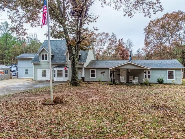 View of front of home with covered porch and roof with shingles