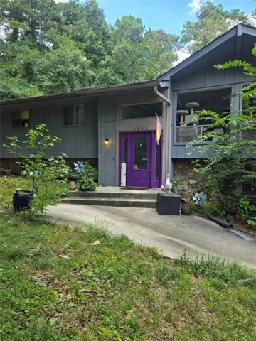 Modern exterior featuring a prominent purple entry door