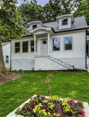 View of front of house featuring a front lawn and roof with shingles
