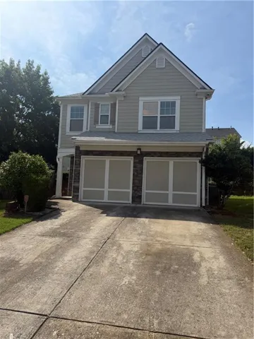Two-story residence featuring light gray siding with white trim accents and a dark roof