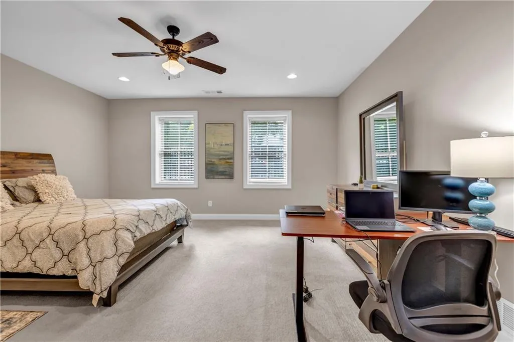 Bedroom featuring a desk, light colored carpet, a ceiling fan, and recessed lighting
