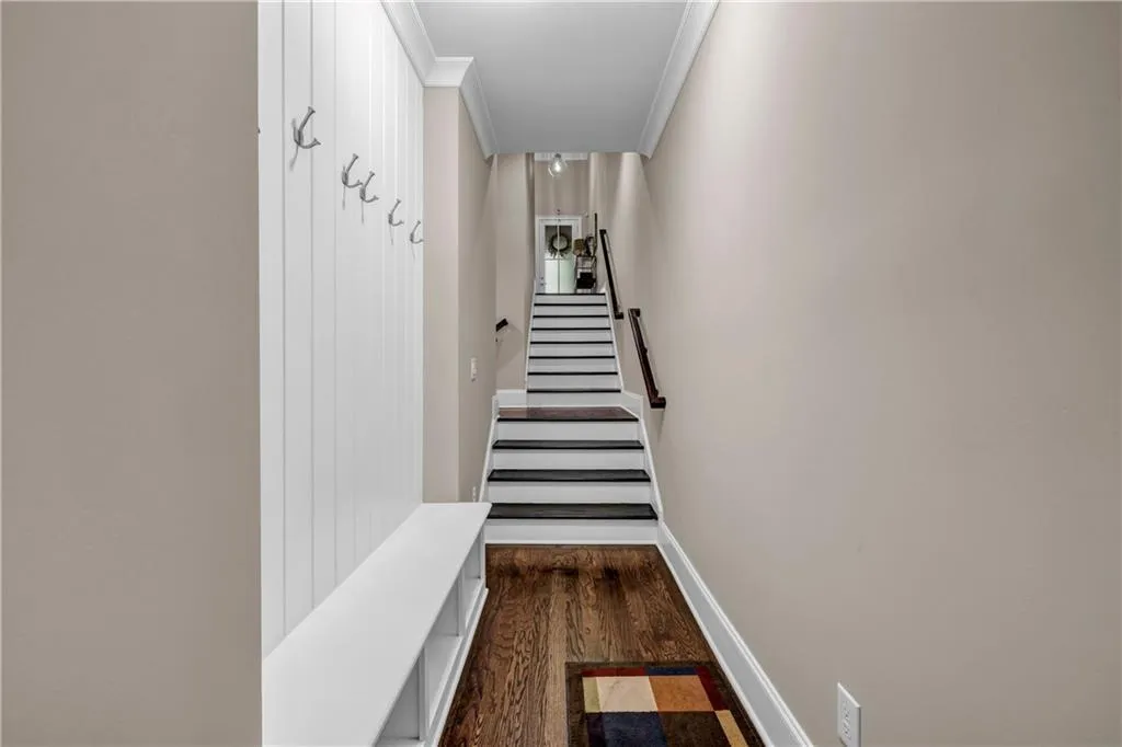 Stairs with wood finished floors and ornamental molding