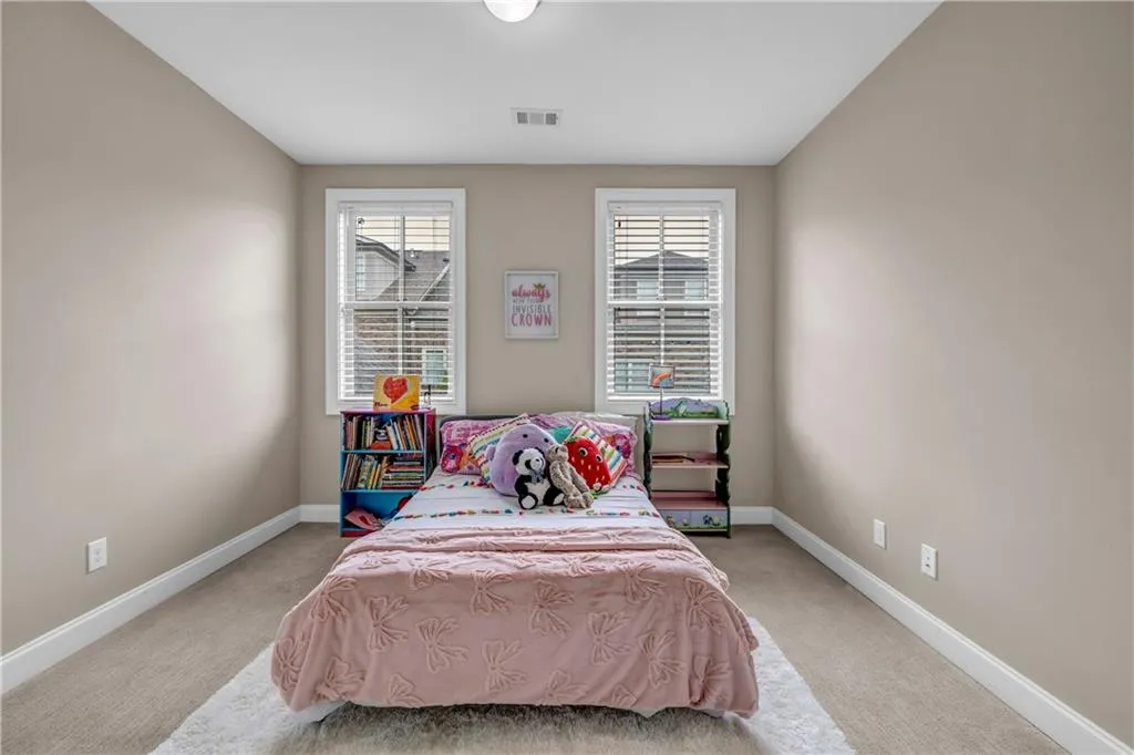 Bedroom with light colored carpet and baseboards