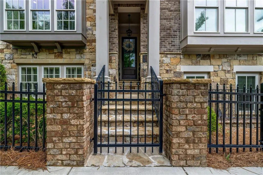 Property entrance featuring stone siding and a gate