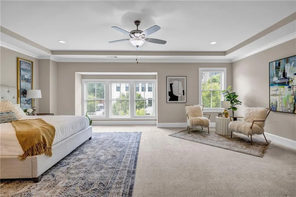Bedroom with carpet, a raised ceiling, ceiling fan, and recessed lighting