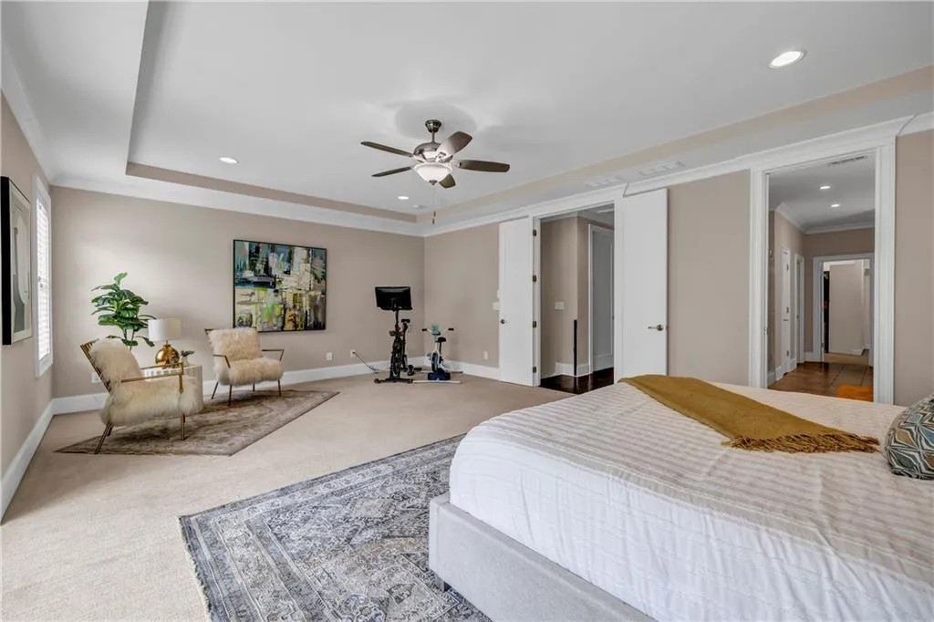Carpeted bedroom with ornamental molding, a tray ceiling, recessed lighting, and ceiling fan