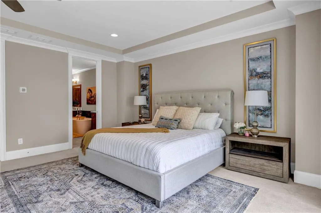 Bedroom featuring carpet floors, crown molding, a raised ceiling, recessed lighting, and connected bathroom
