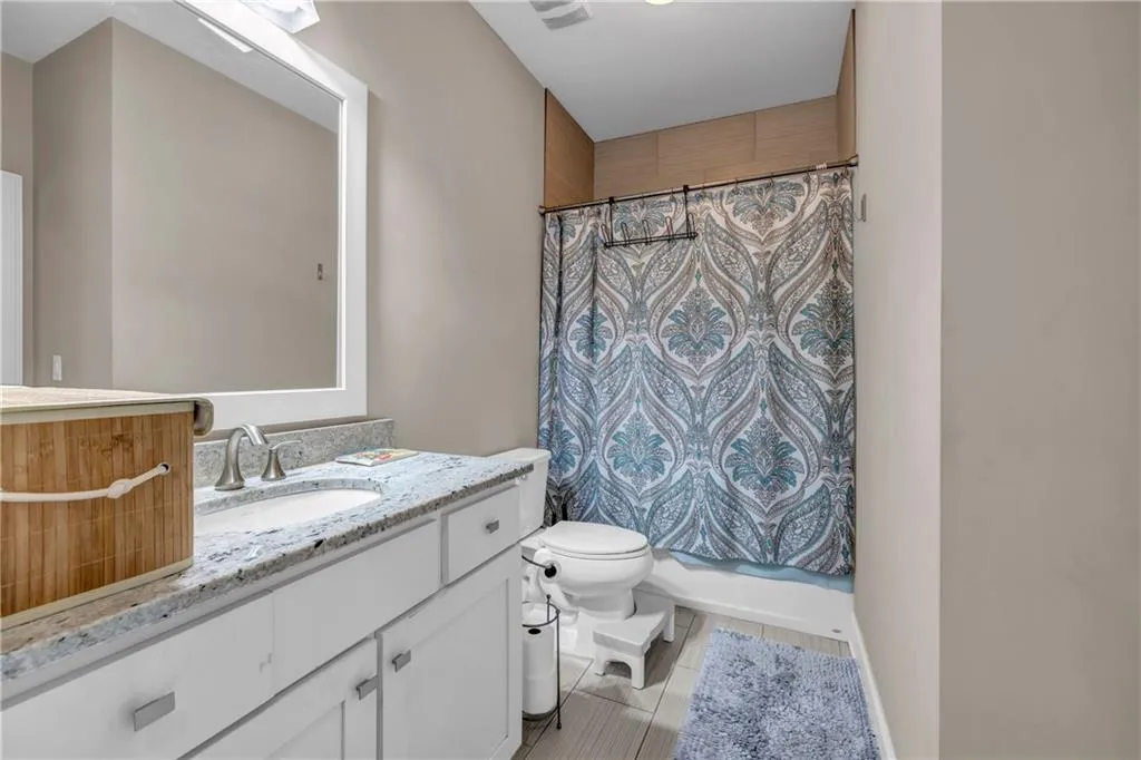 Full bath with vanity, a shower with shower curtain, and light wood-type flooring