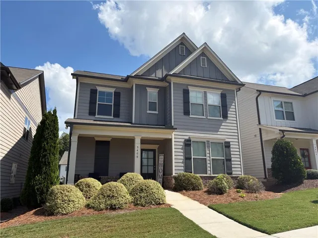 Two-story exterior featuring a prominent gable roof, vertical siding accents, a covered entry porch, and a concrete walkway