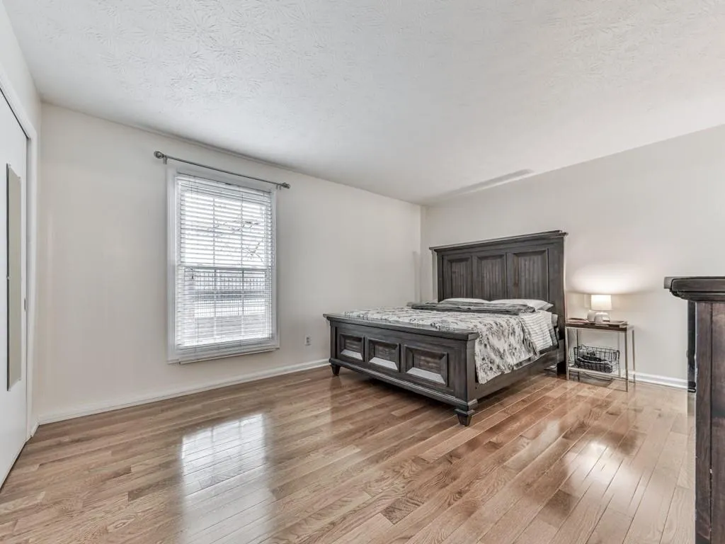 Bedroom with a textured ceiling and light wood-type flooring